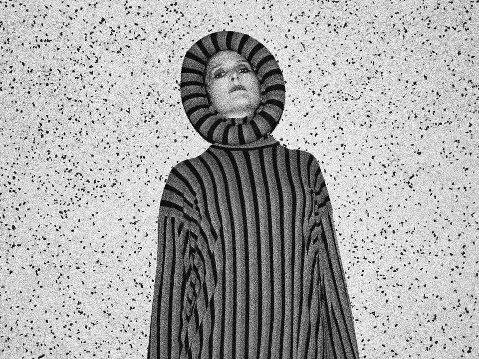 Cate Le Bon wears an oversized striped jumper with hood.
