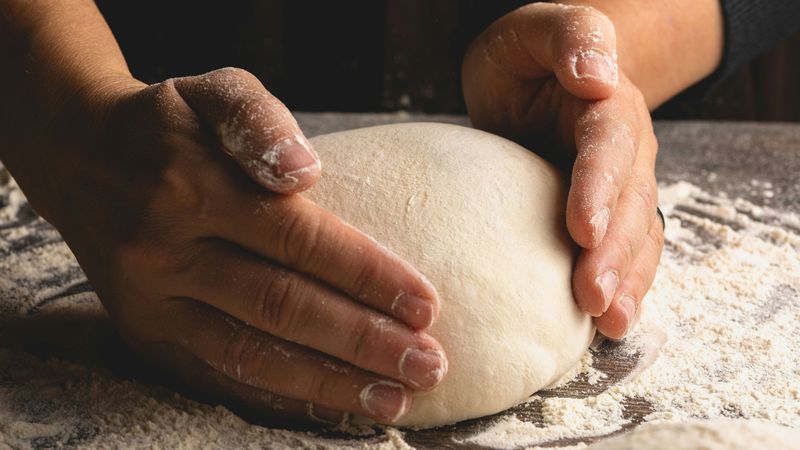 Krupni plan hrskavog sourdough hleba sa šupljikavom sredinom.