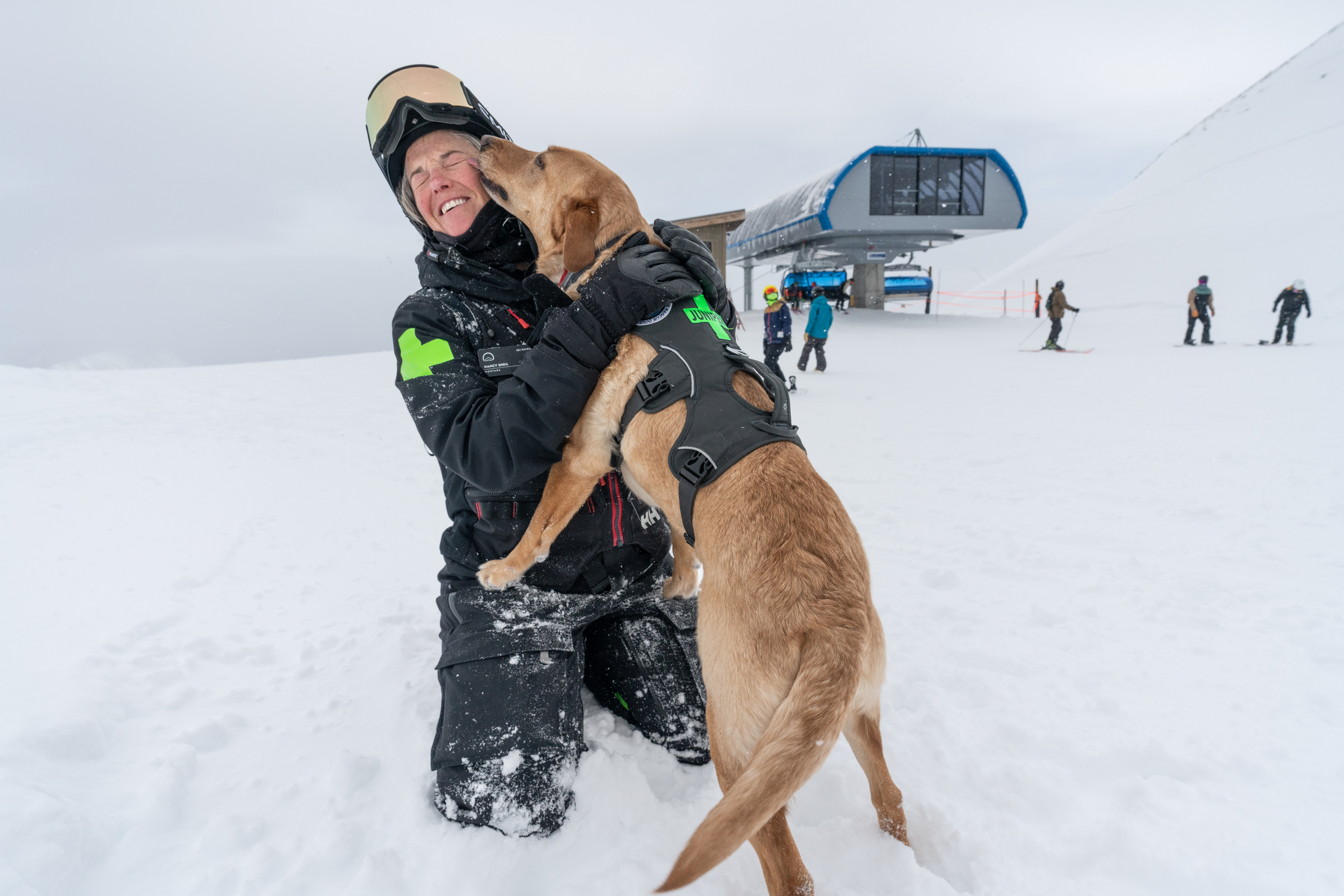 A Big Sky Resort ski patroller with her patrol dog in winter