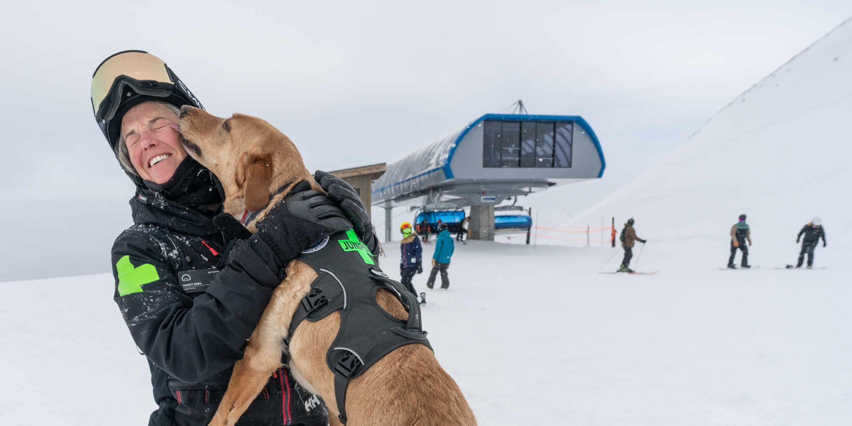 A Big Sky Resort ski patroller with her patrol dog in winter