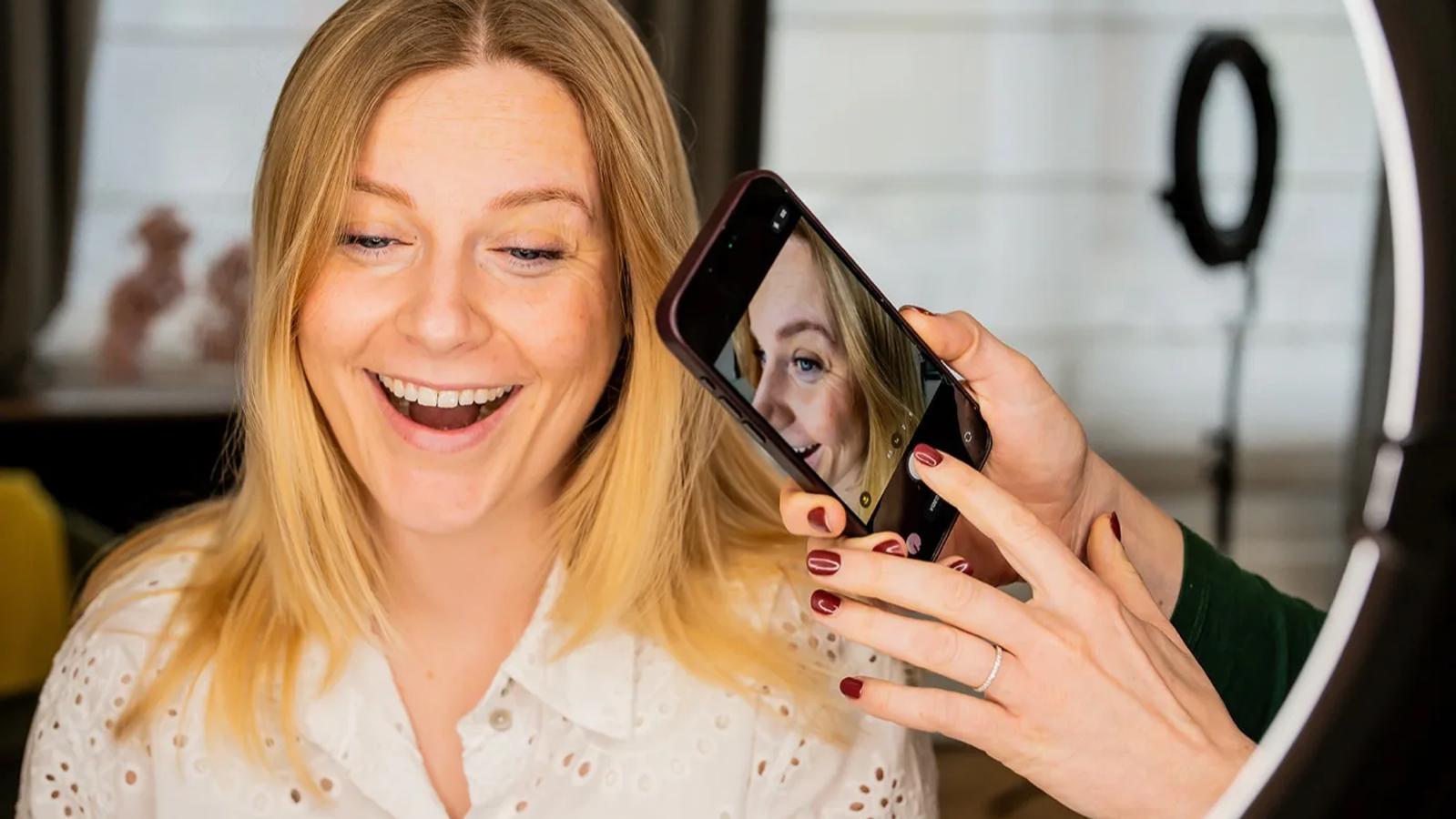 Klante bekijkt lachend het resultaat van haar lip blush behandeling