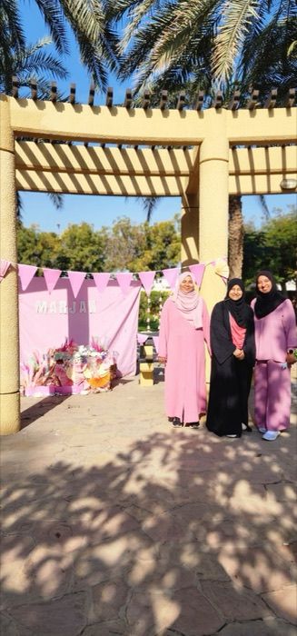 Dubai chapter members at a pink-themed celebration backdrop
