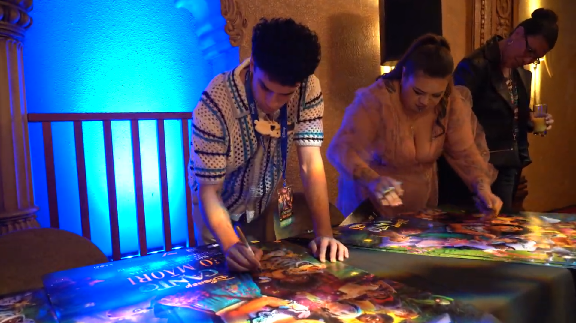 Poroaki Merrit-McDonald (left) and Awatea Wihongi signing posters with Pānia Papa (background)