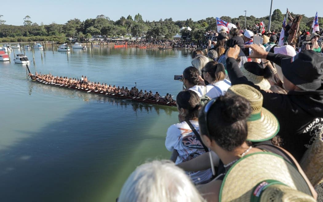 Onlookers on the bridge excitedly watch the annual waka exhibition and the world's largest ceremonial waka, Ngātokimatawhaorua Waka. Photo/RNZ