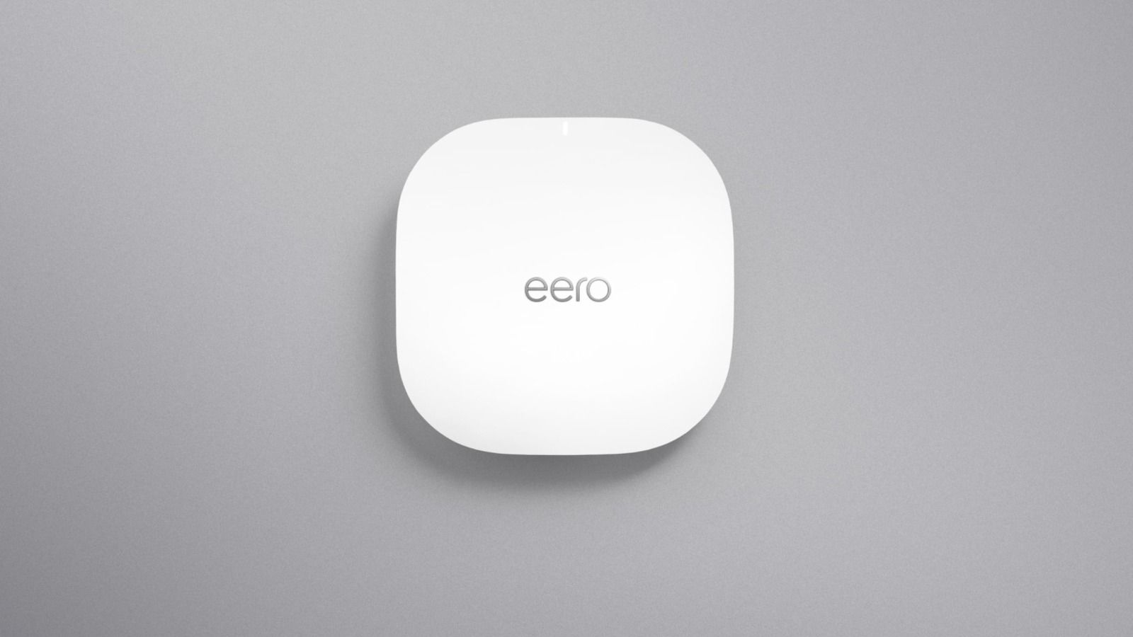 White eero PoE 6 access point mounted on a gray wall.