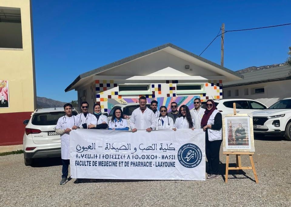 Étudiants de la Faculté de Médecine de Laâyoune posant avec une banderole lors d'une mission solidaire à Ounan