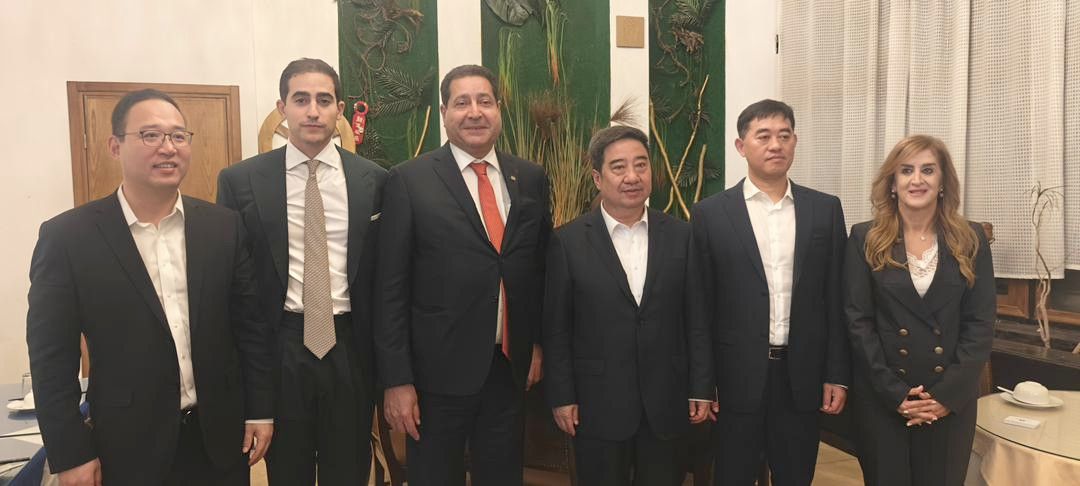 Six représentants officiels en costume posant debout lors du dîner avec le président de Sinopharm
