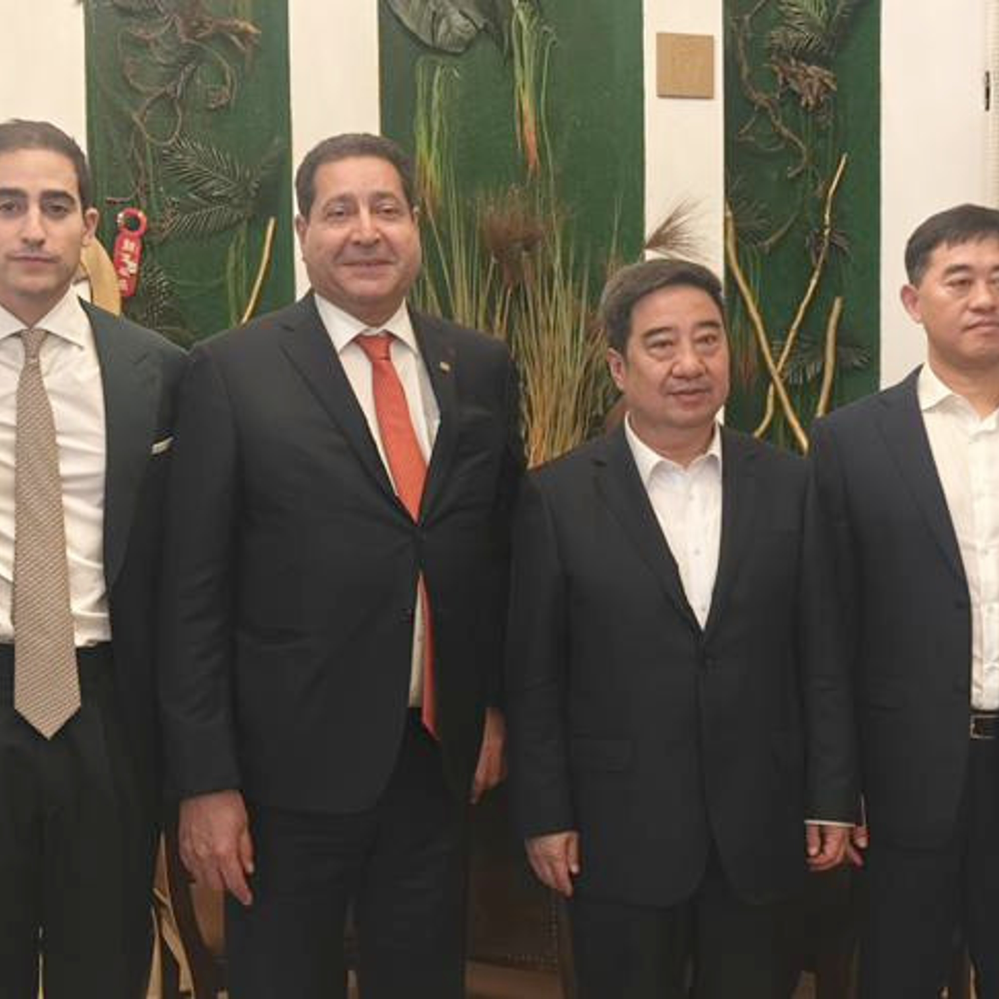 Six représentants officiels en costume posant debout lors du dîner avec le président de Sinopharm