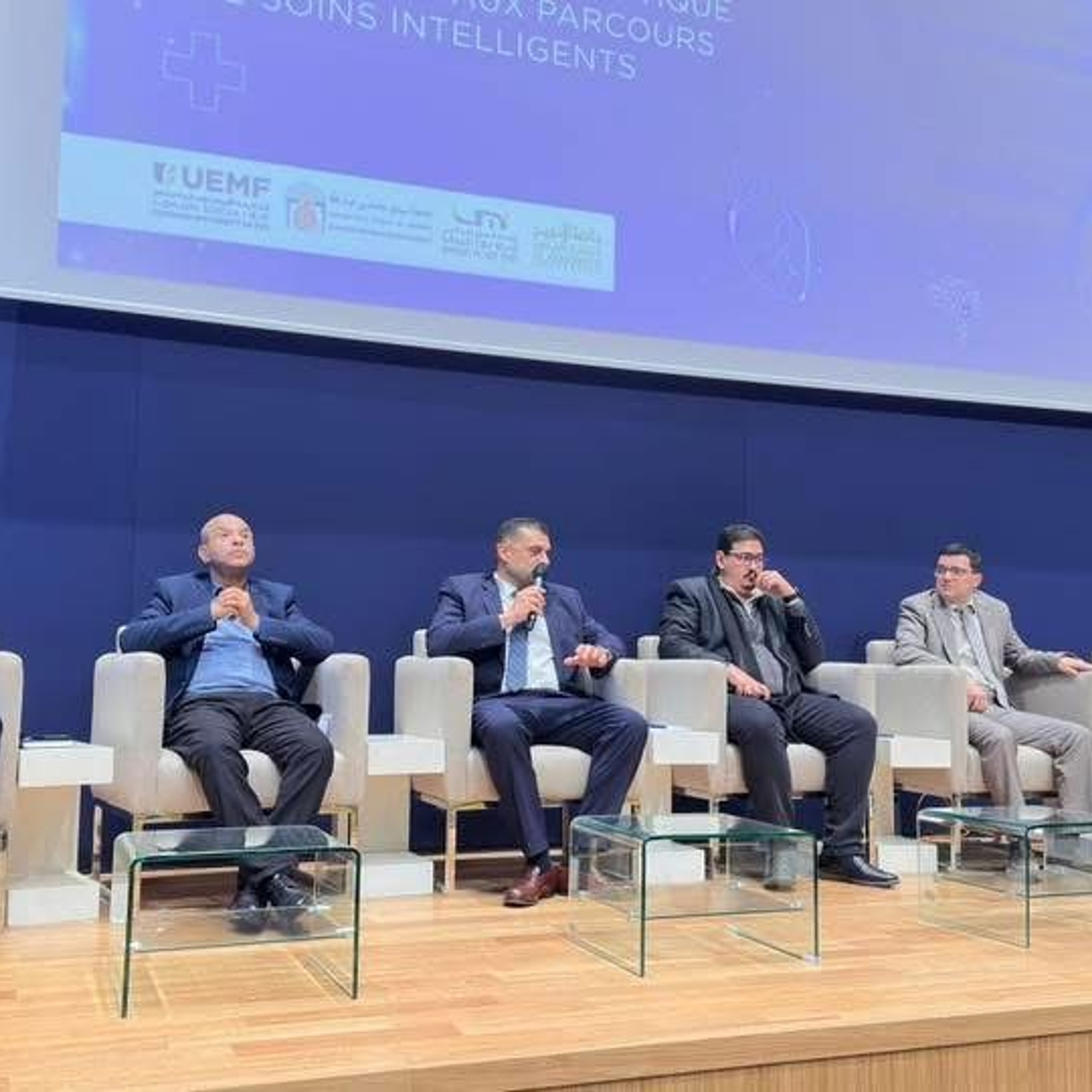 Six intervenants assis sur scène lors d'une table ronde à la conférence UEMF sur l'intelligence artificielle