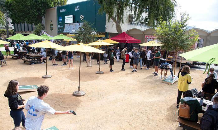 Guests playing cornhole and visiting food trucks. 