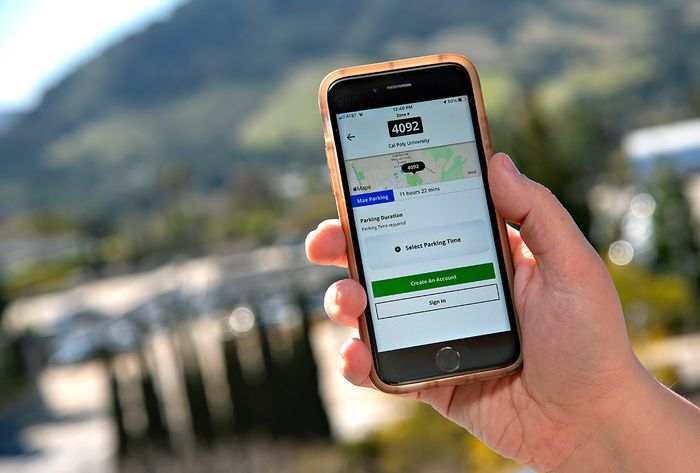 Hand holding an iPhone with the ParkMobile app displayed