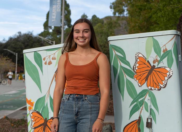 Cal Poly student Katelyn Lowry with her painted utility box.