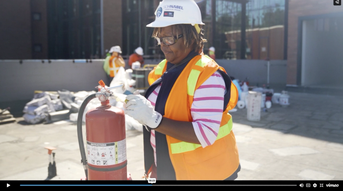 Melonee Cruse inspects a fire extinguisher at the Frost Center construction site in a screenshot from the A&F Leap Forward video 