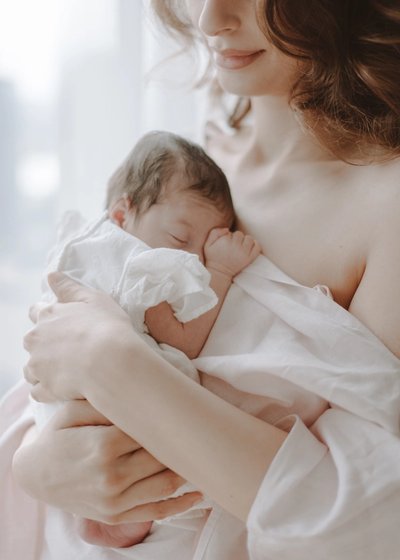 Newborn baby photographed with an older sibling in a bright family home