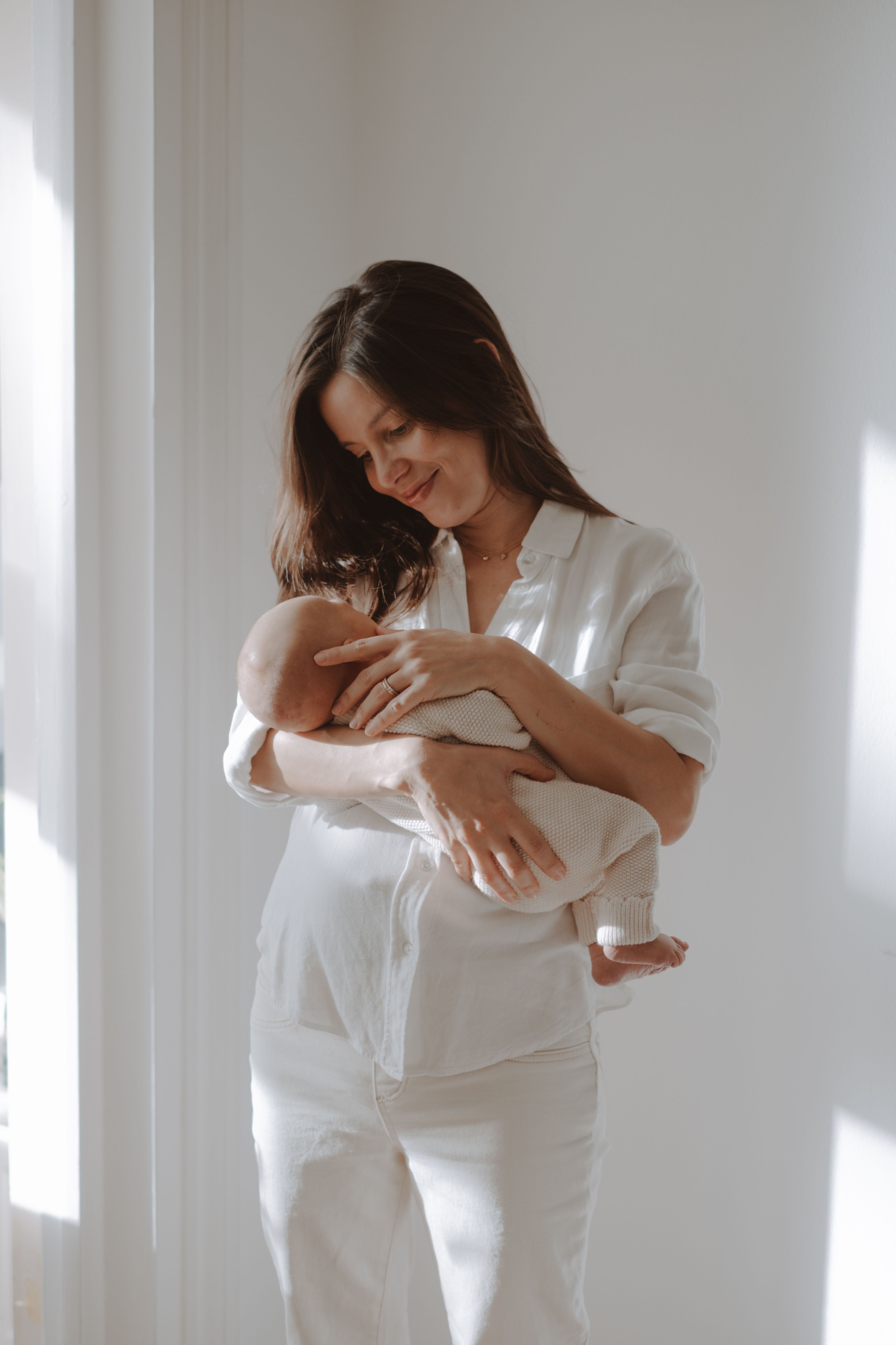 Close portrait of a newborn baby wrapped in soft neutral blankets