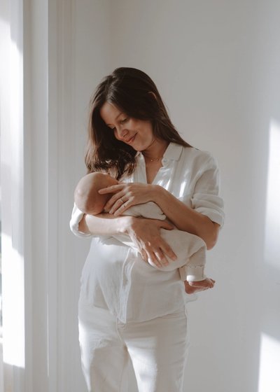 Close portrait of a newborn baby wrapped in soft neutral blankets