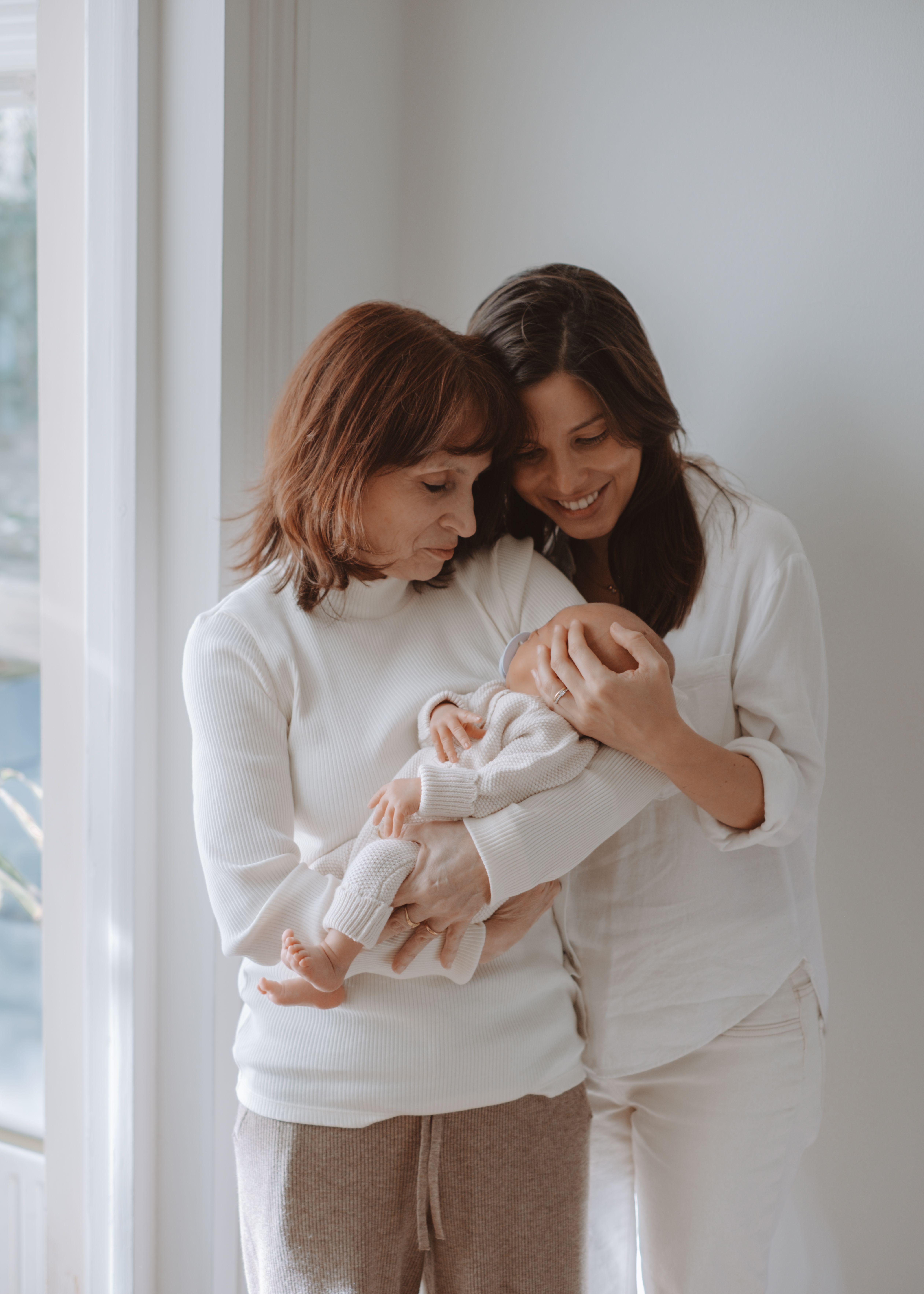 Mother cuddling her newborn baby during an intimate at-home photography session