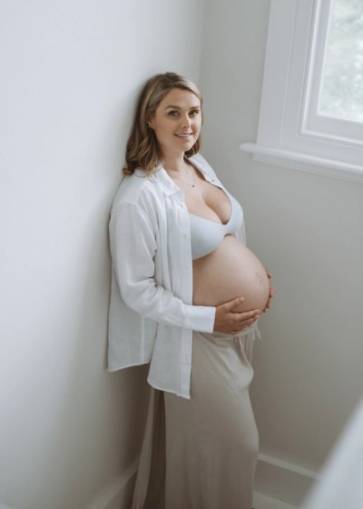 Natural seated portrait of an expectant mother in neutral clothing