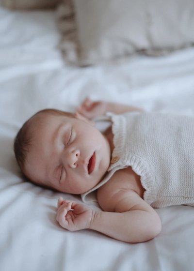 Parent gently holding their newborn baby beside a softly lit window at home