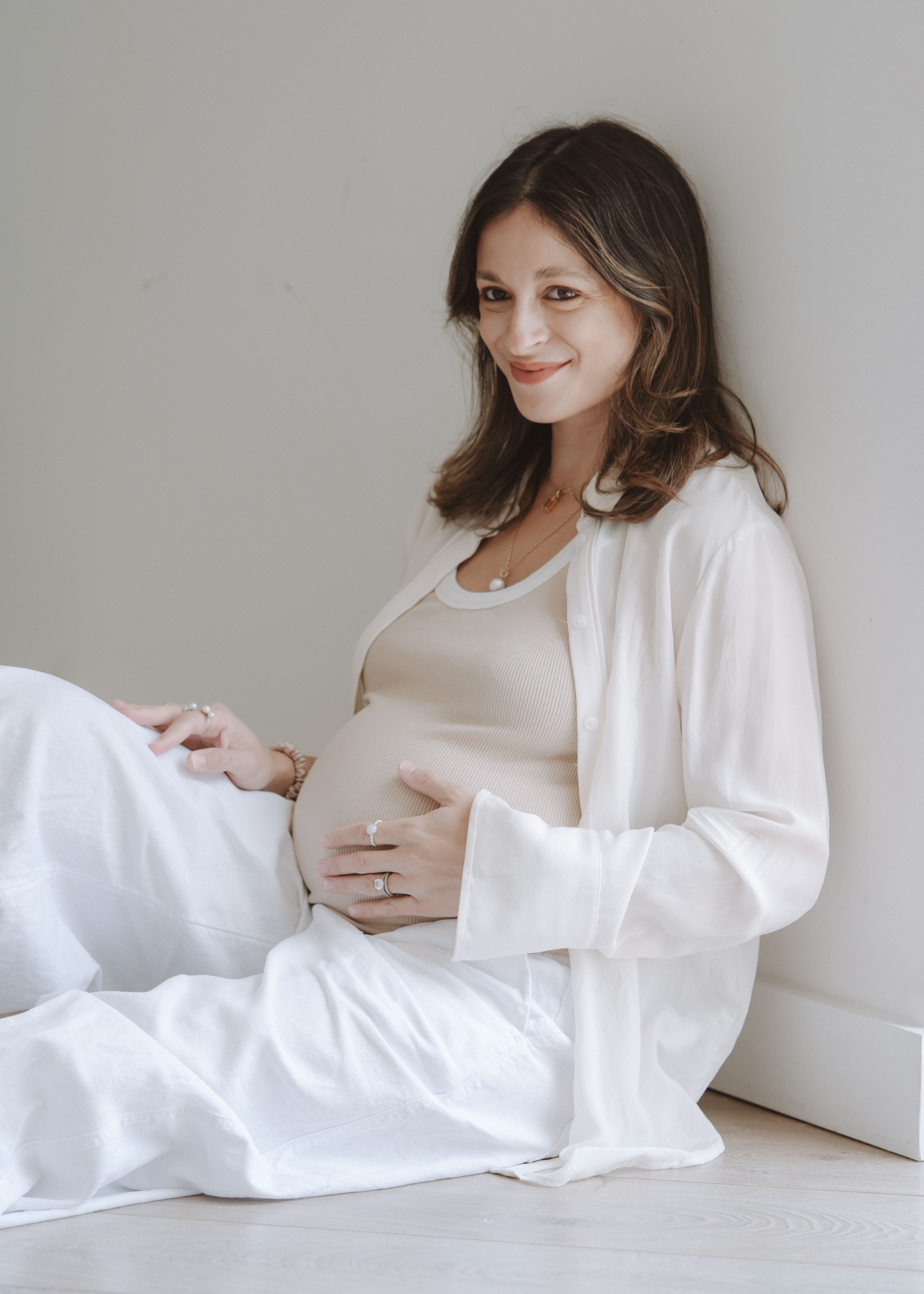 Pregnant mother standing in soft natural light during a relaxed maternity session