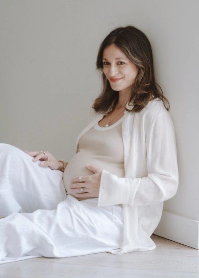 Pregnant mother standing in soft natural light during a relaxed maternity session