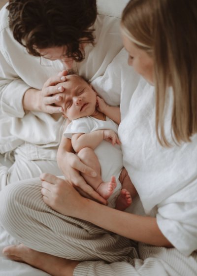 Newborn baby lying comfortably on a bed in soft natural light