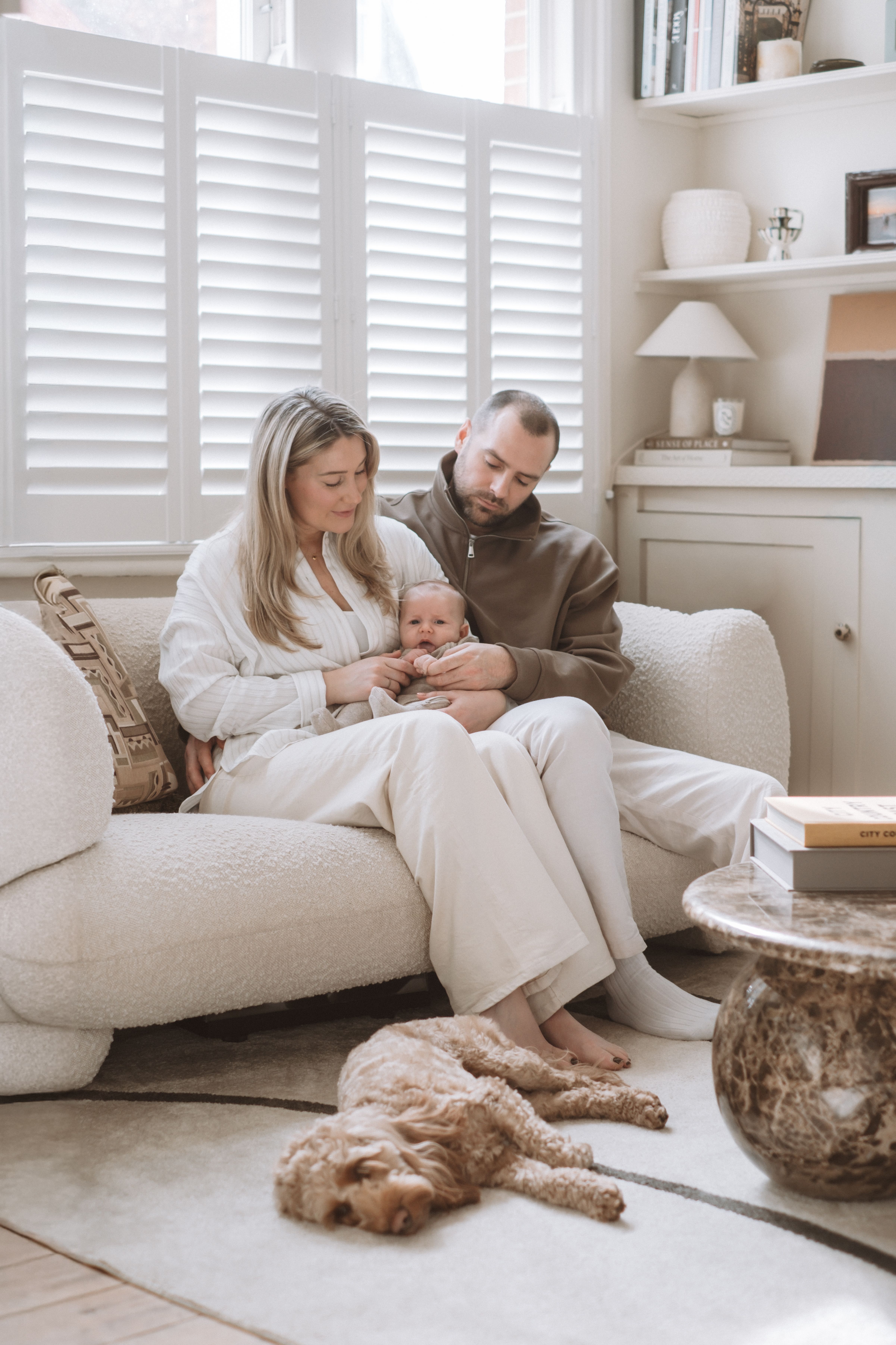 Newborn baby photographed with an older sibling in a bright family home