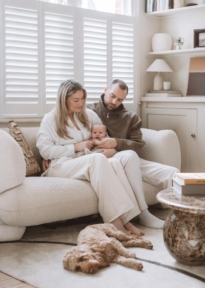 Newborn baby photographed with an older sibling in a bright family home