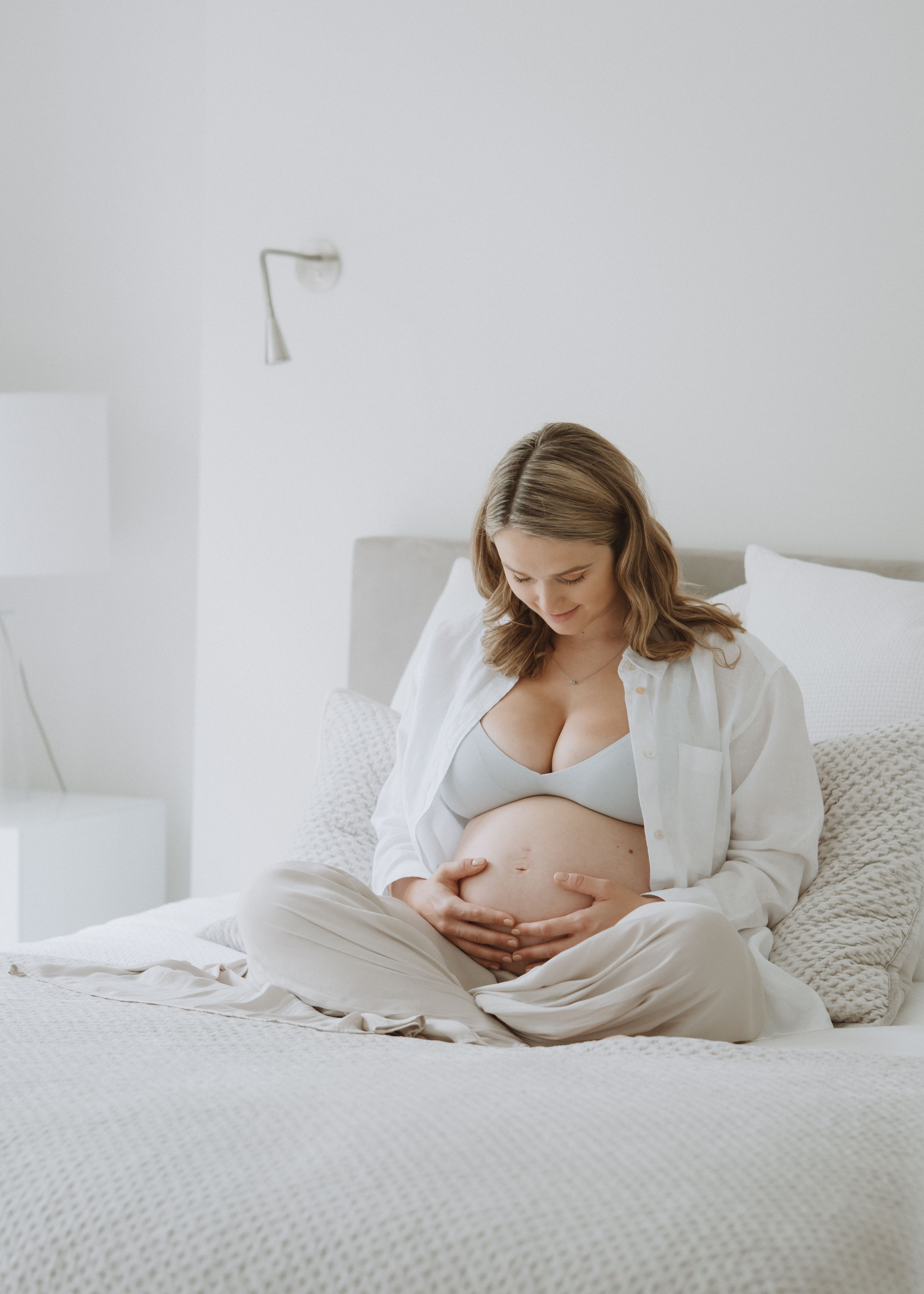 Natural pregnancy portrait beside a window in a softly lit London home
