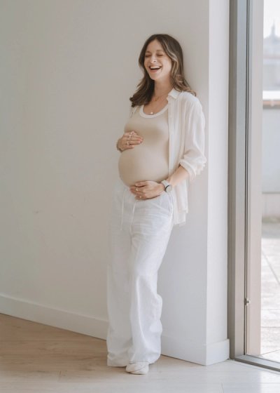 Natural seated portrait of an expectant mother in neutral clothing