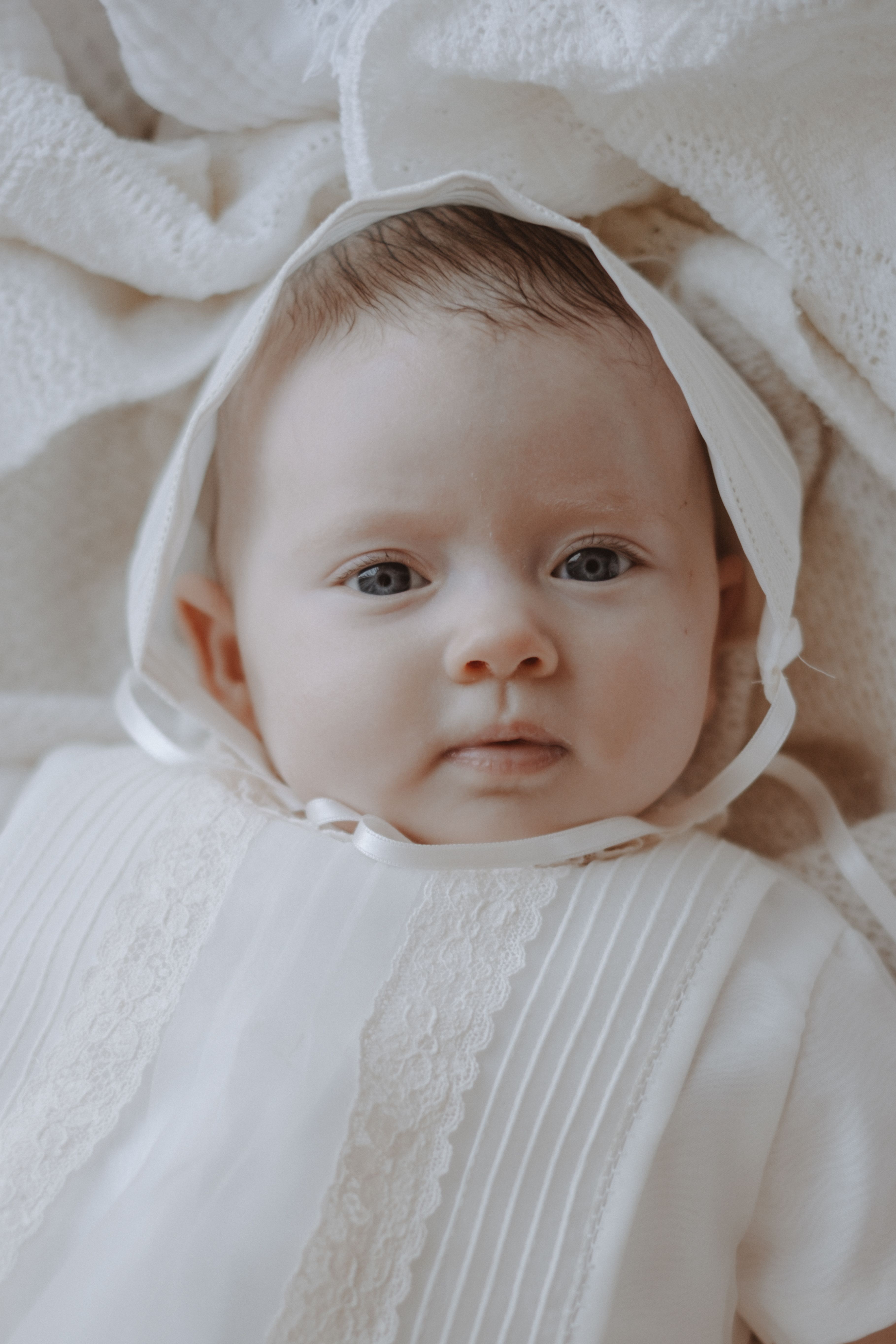 Close portrait of a newborn baby wrapped in soft neutral blankets
