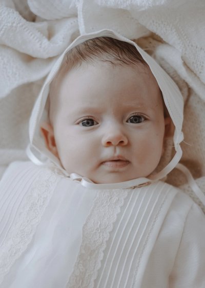 Close portrait of a newborn baby wrapped in soft neutral blankets