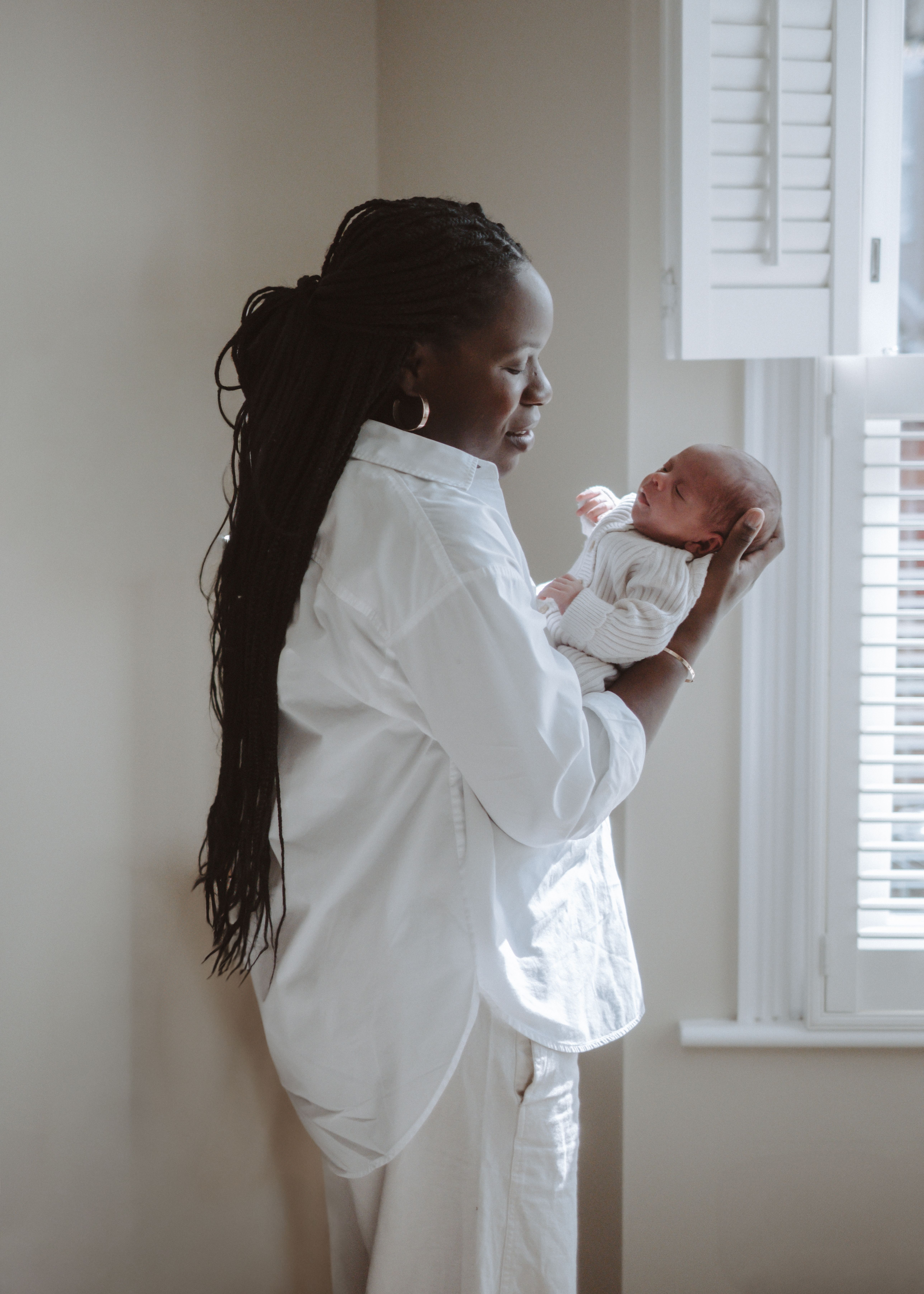Father holding his newborn baby in soft natural light at home