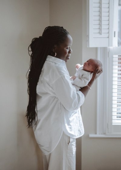 Father holding his newborn baby in soft natural light at home