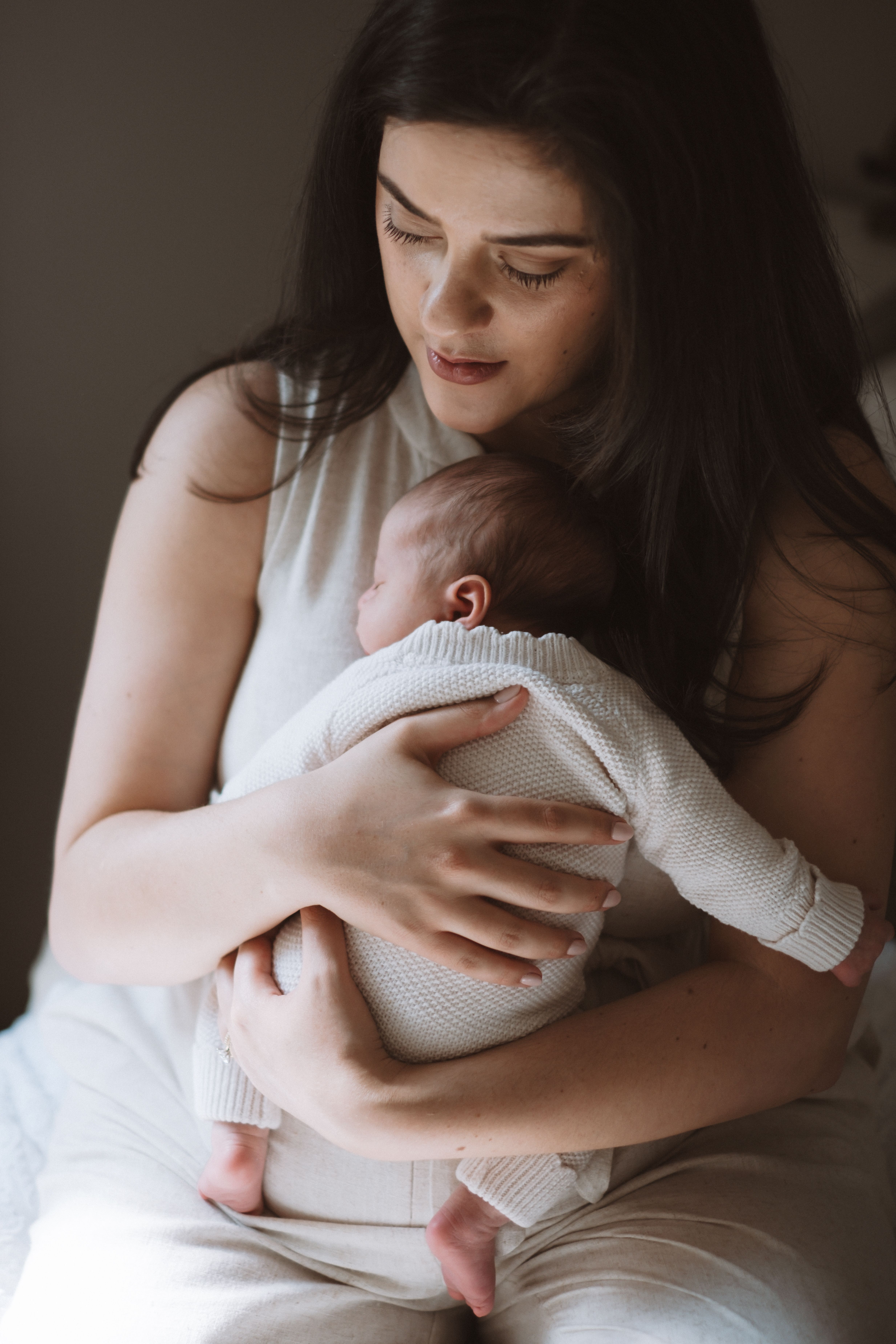 Newborn baby lying comfortably on a bed in soft natural light