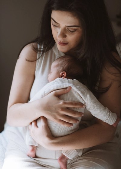 Newborn baby lying comfortably on a bed in soft natural light
