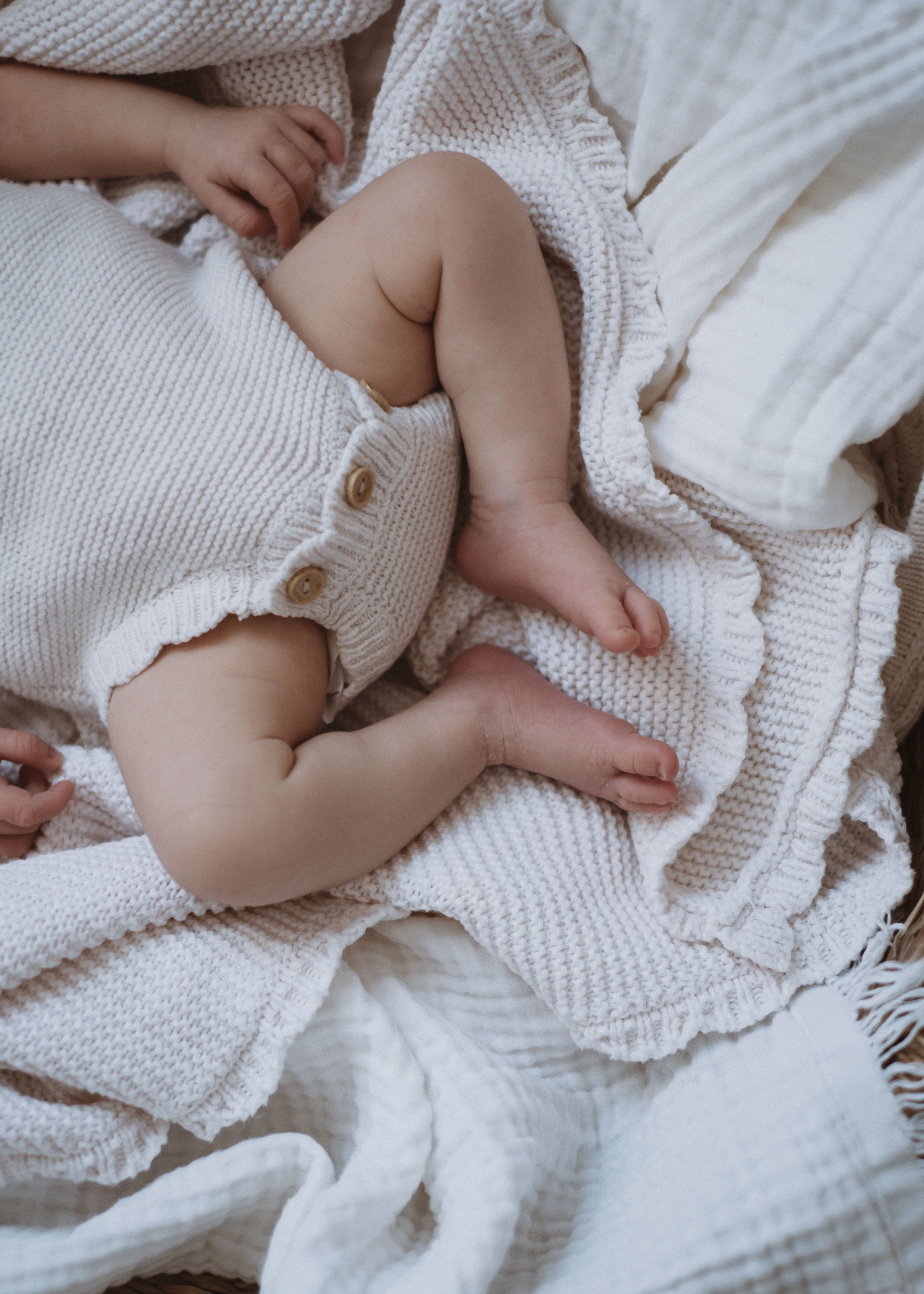 Newborn baby lying comfortably on a bed in soft natural light