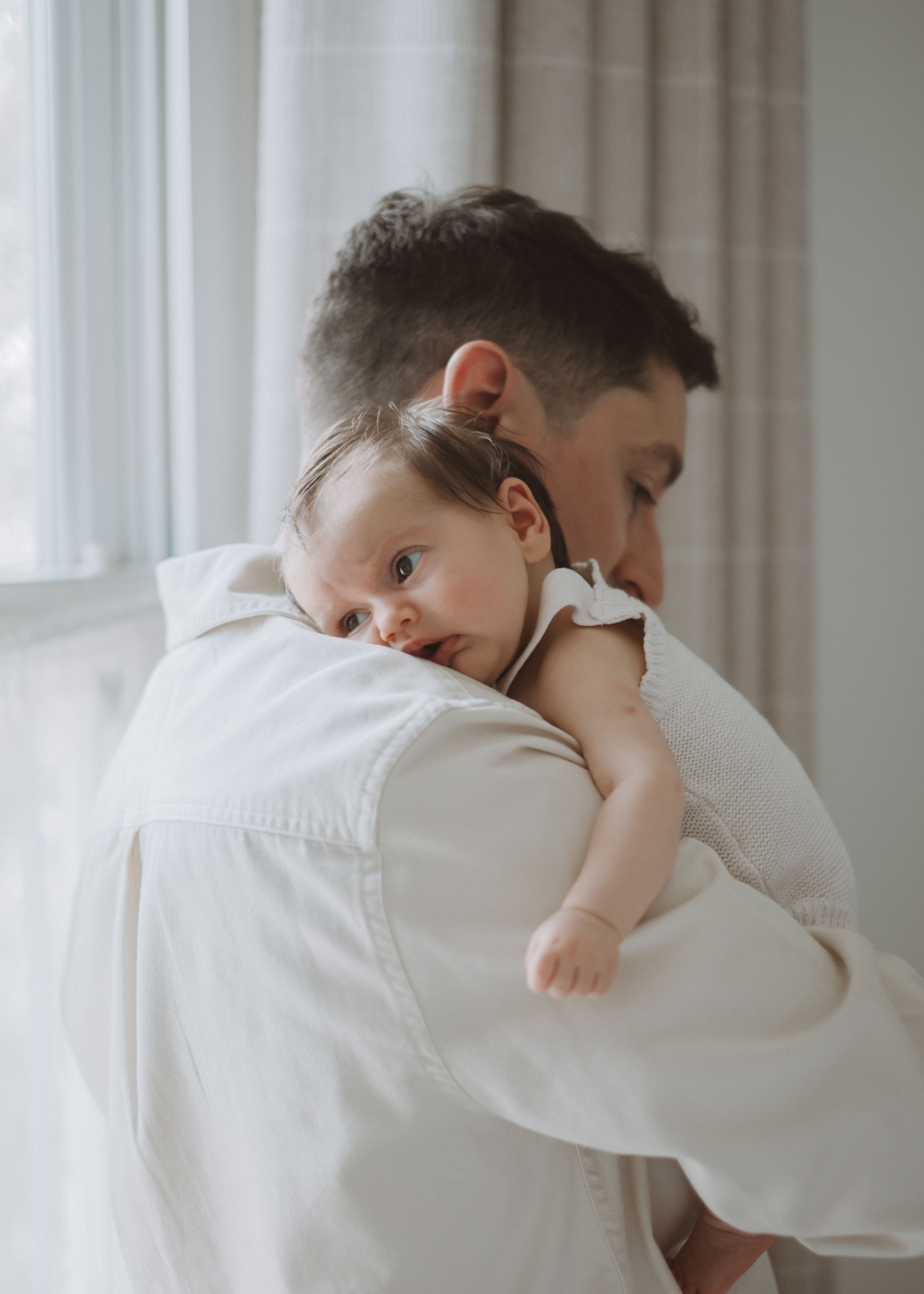 Newborn baby lying comfortably on a bed in soft natural light