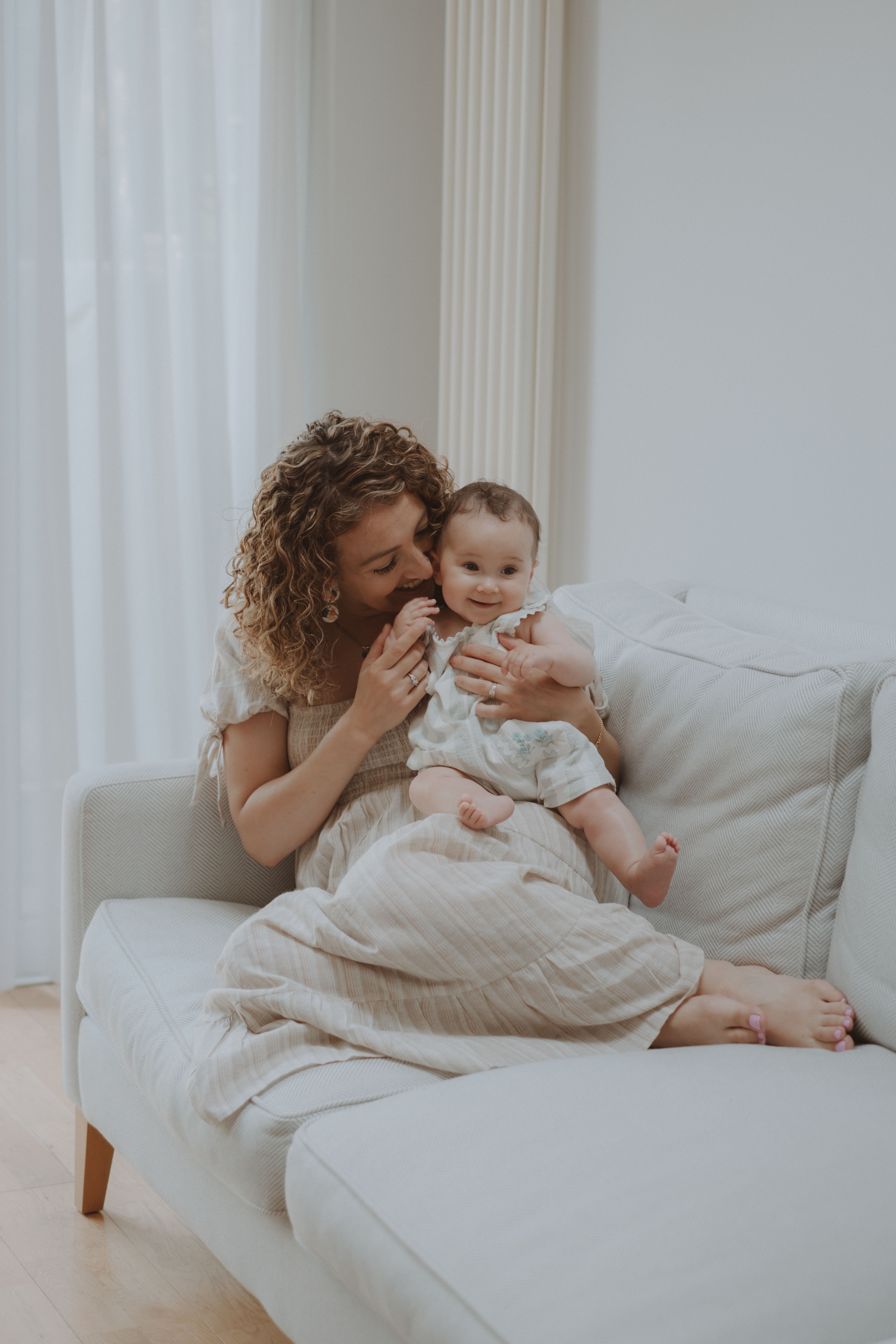 Mother cuddling her newborn baby during an intimate at-home photography session