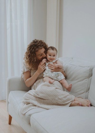 Mother cuddling her newborn baby during an intimate at-home photography session