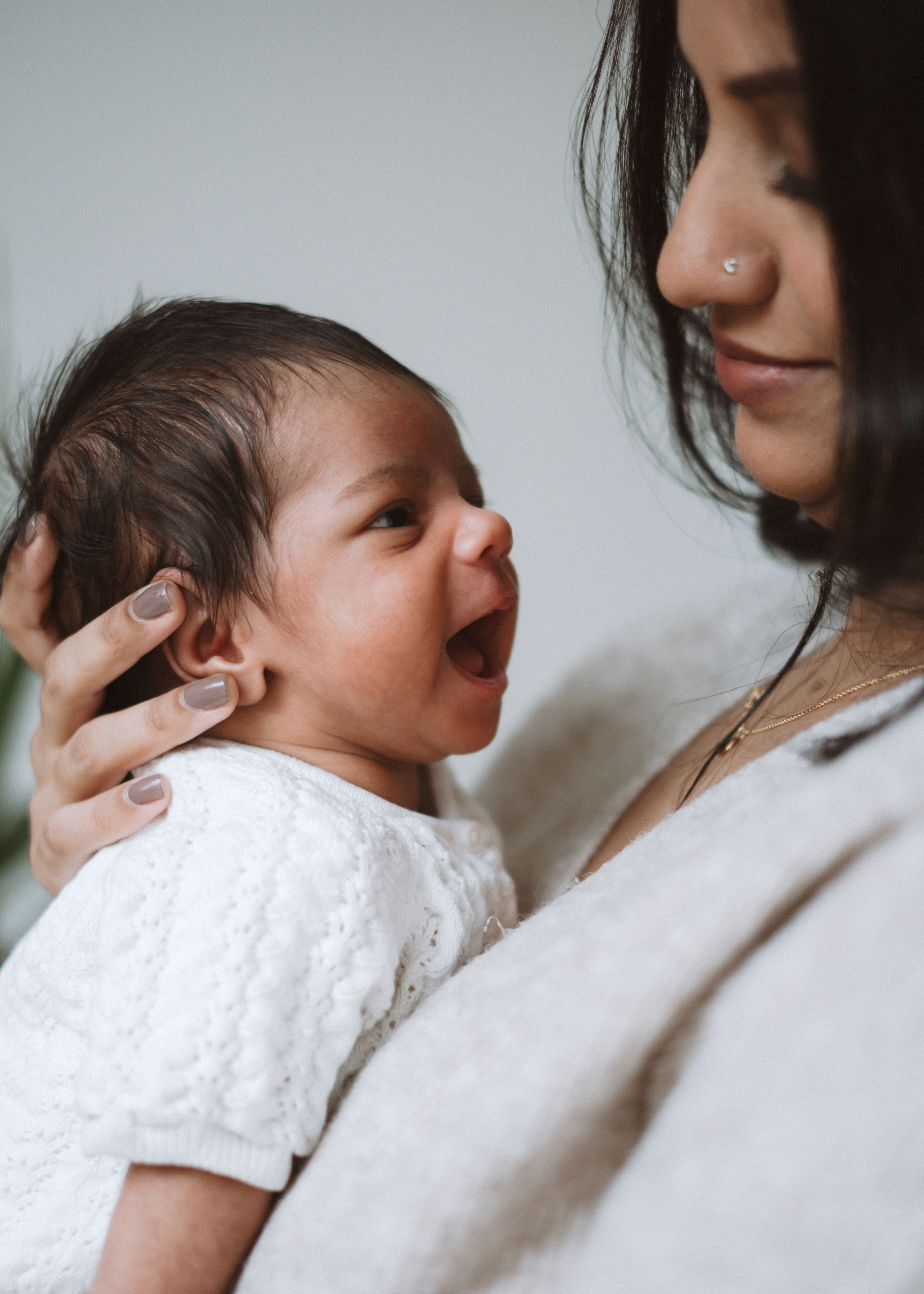 Close portrait of a newborn baby wrapped in soft neutral blankets