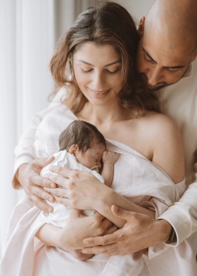 Newborn baby lying comfortably on a bed in soft natural light