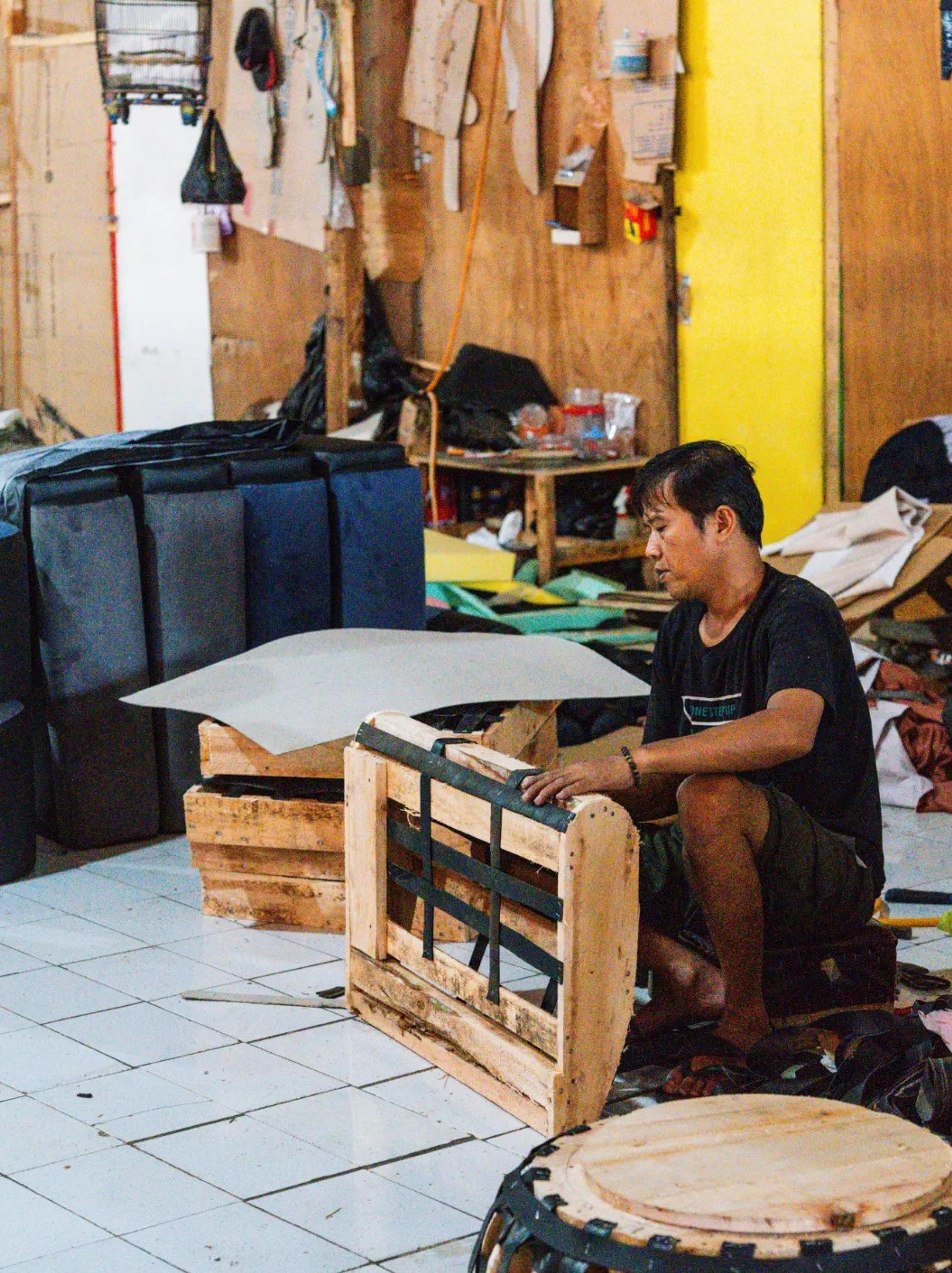 Perajin memeriksa rangka kayu dan webbing sofa