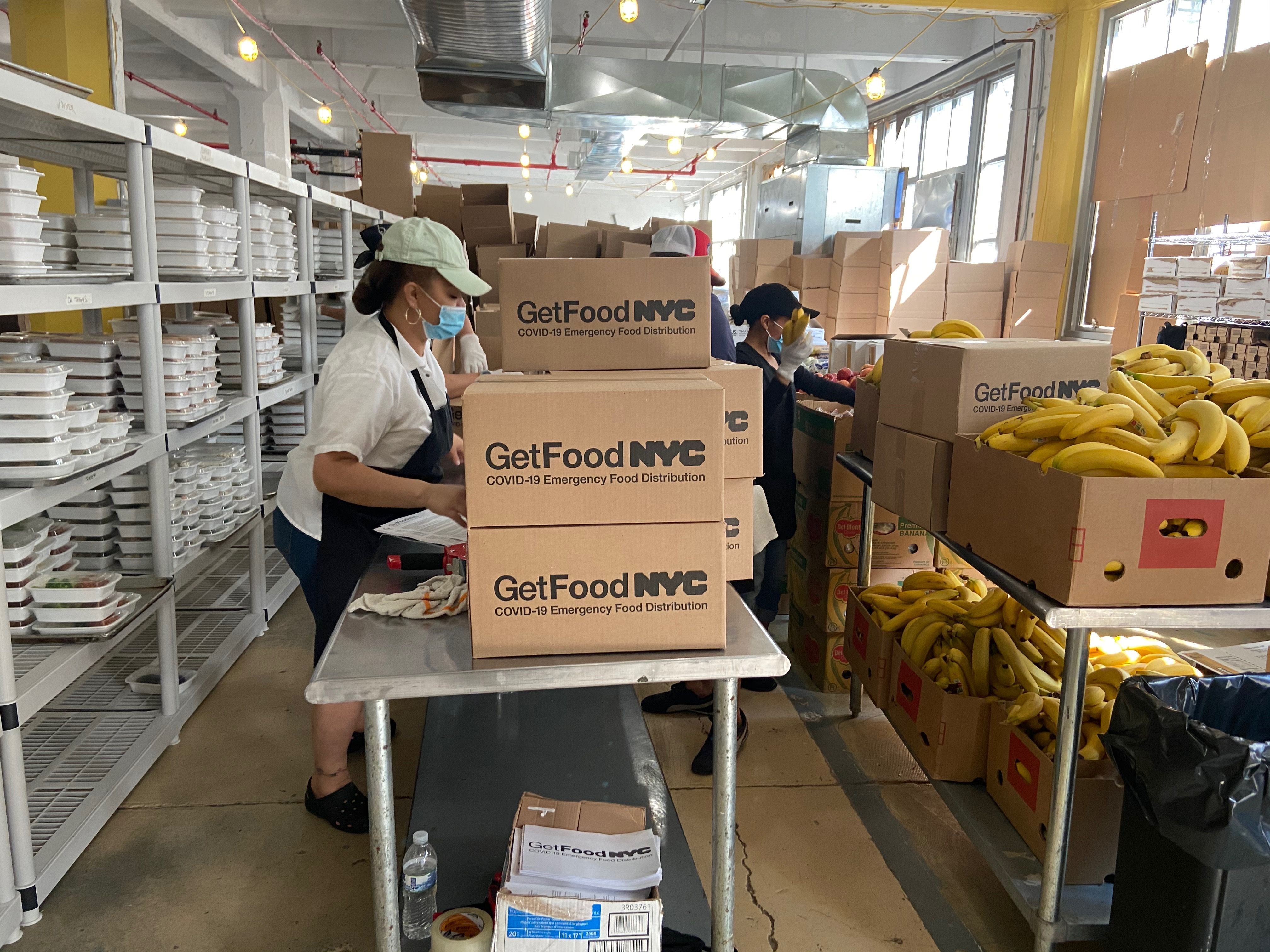 Kitchen staff packing meals and food boxes for emergency disaster relief catering.