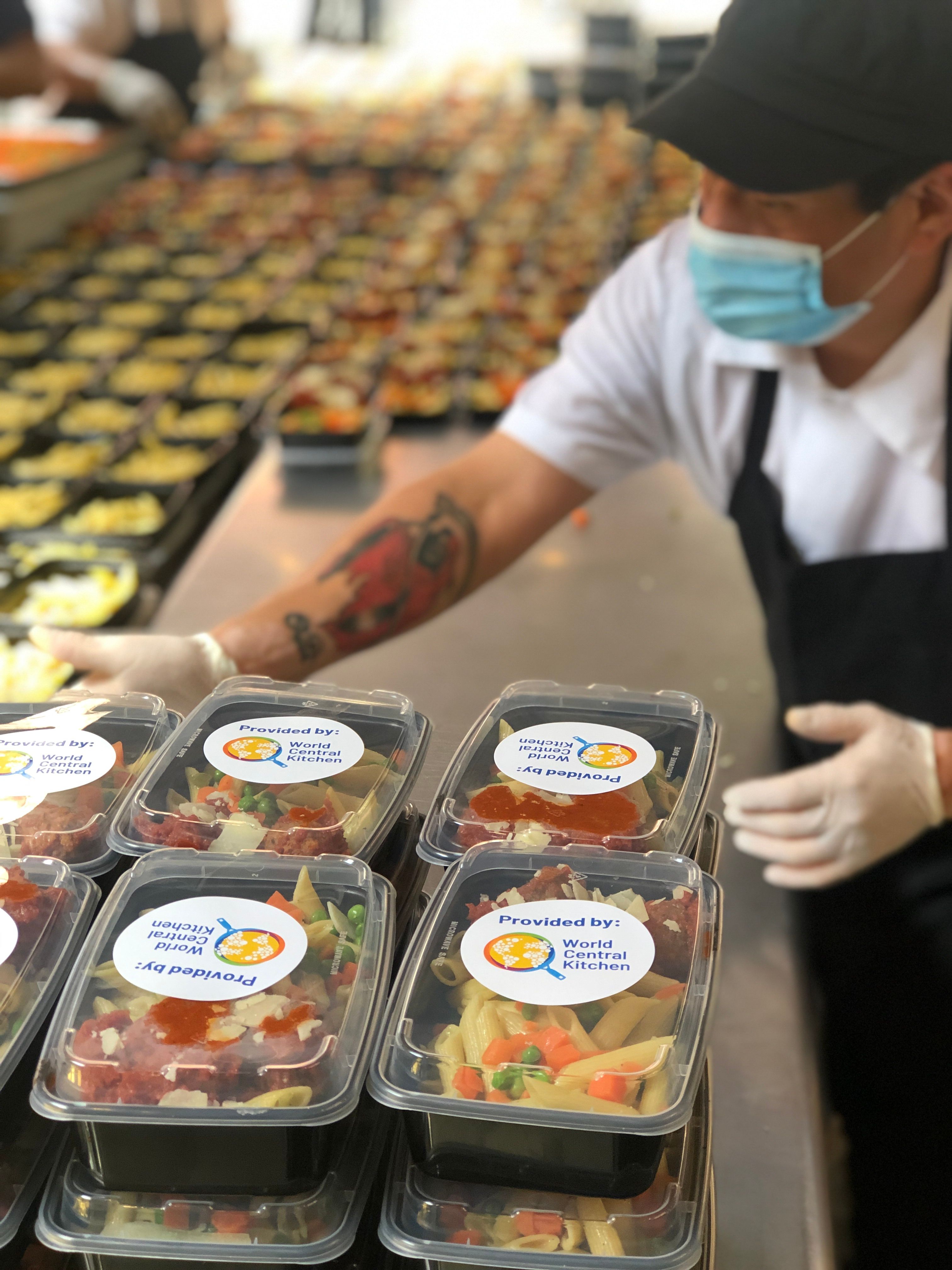 Kitchen staff packaging prepared meals for disaster relief and emergency food distribution.