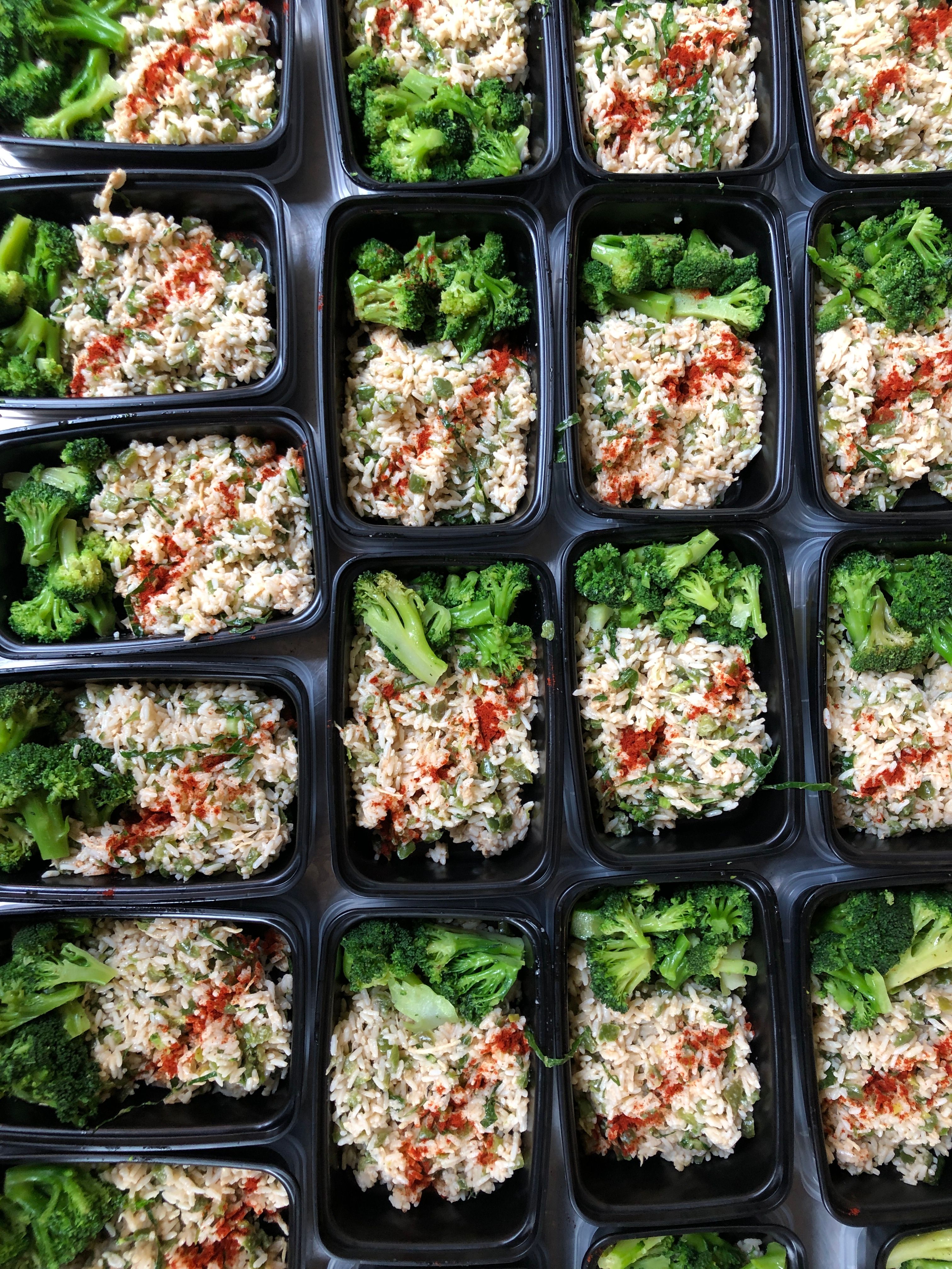 Rows of prepared rice and broccoli meals packaged for large-scale emergency meal distribution.