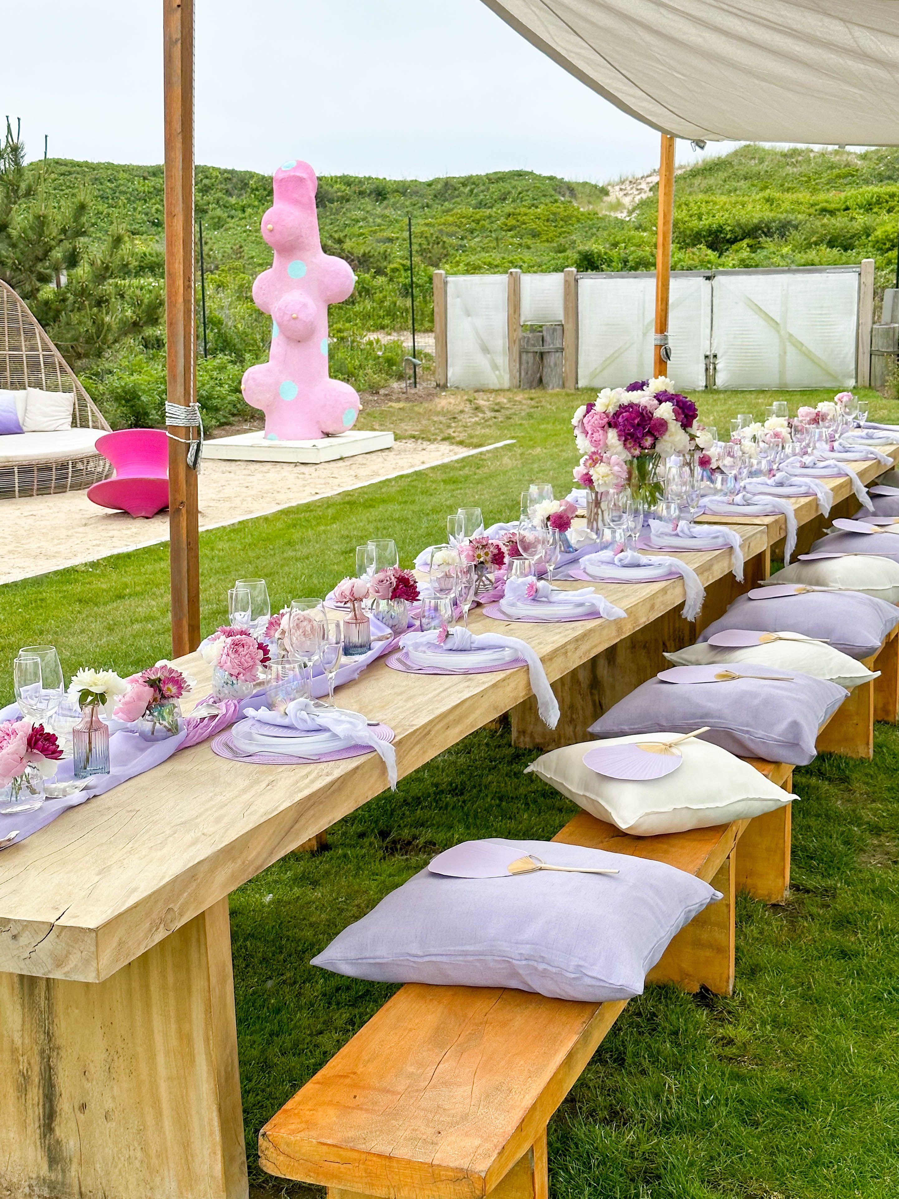 Elegant outdoor wedding reception table with floral centerpieces and lavender linens.