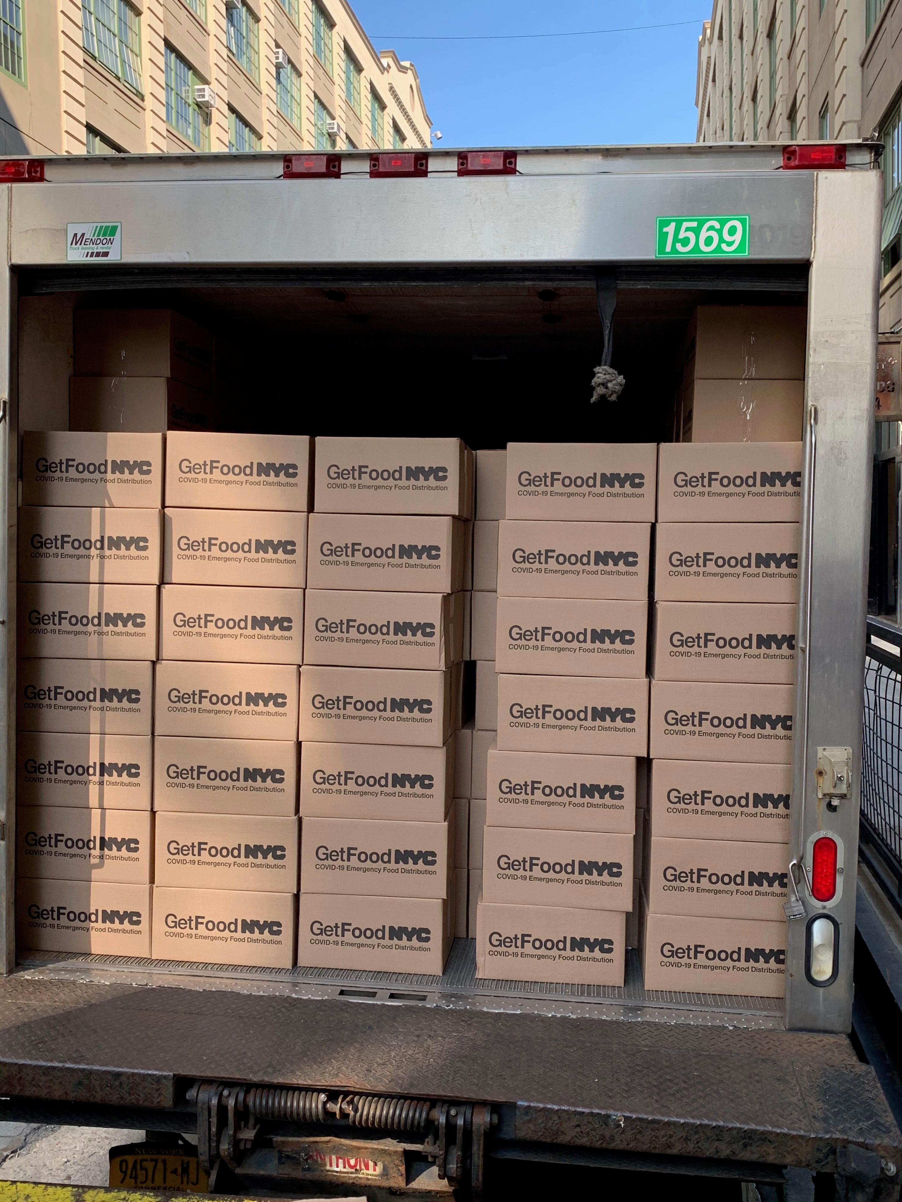 Delivery truck loaded with boxed meals for emergency food distribution services.