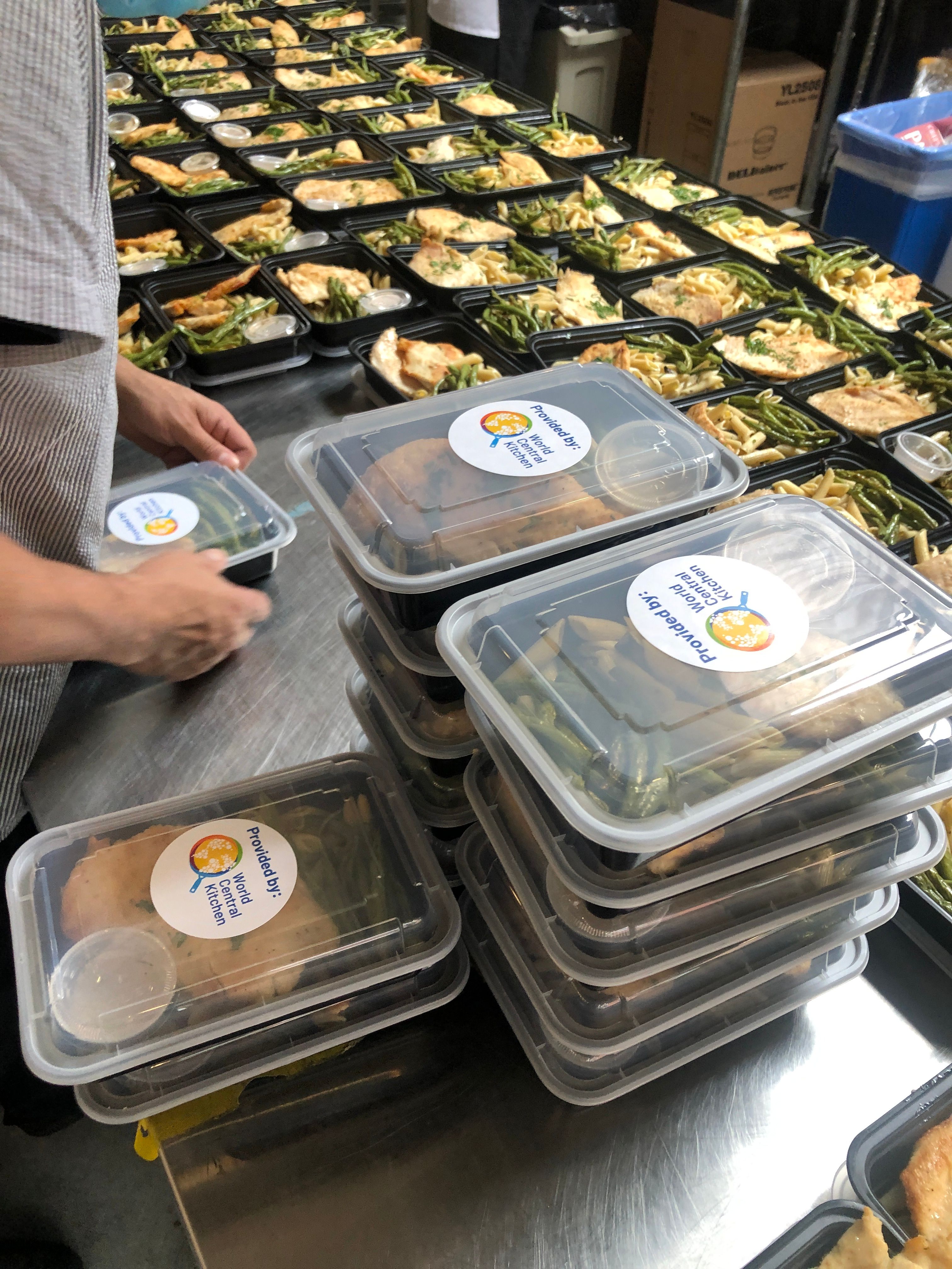 Stacked packaged meals prepared in a commercial kitchen for emergency food relief programs.