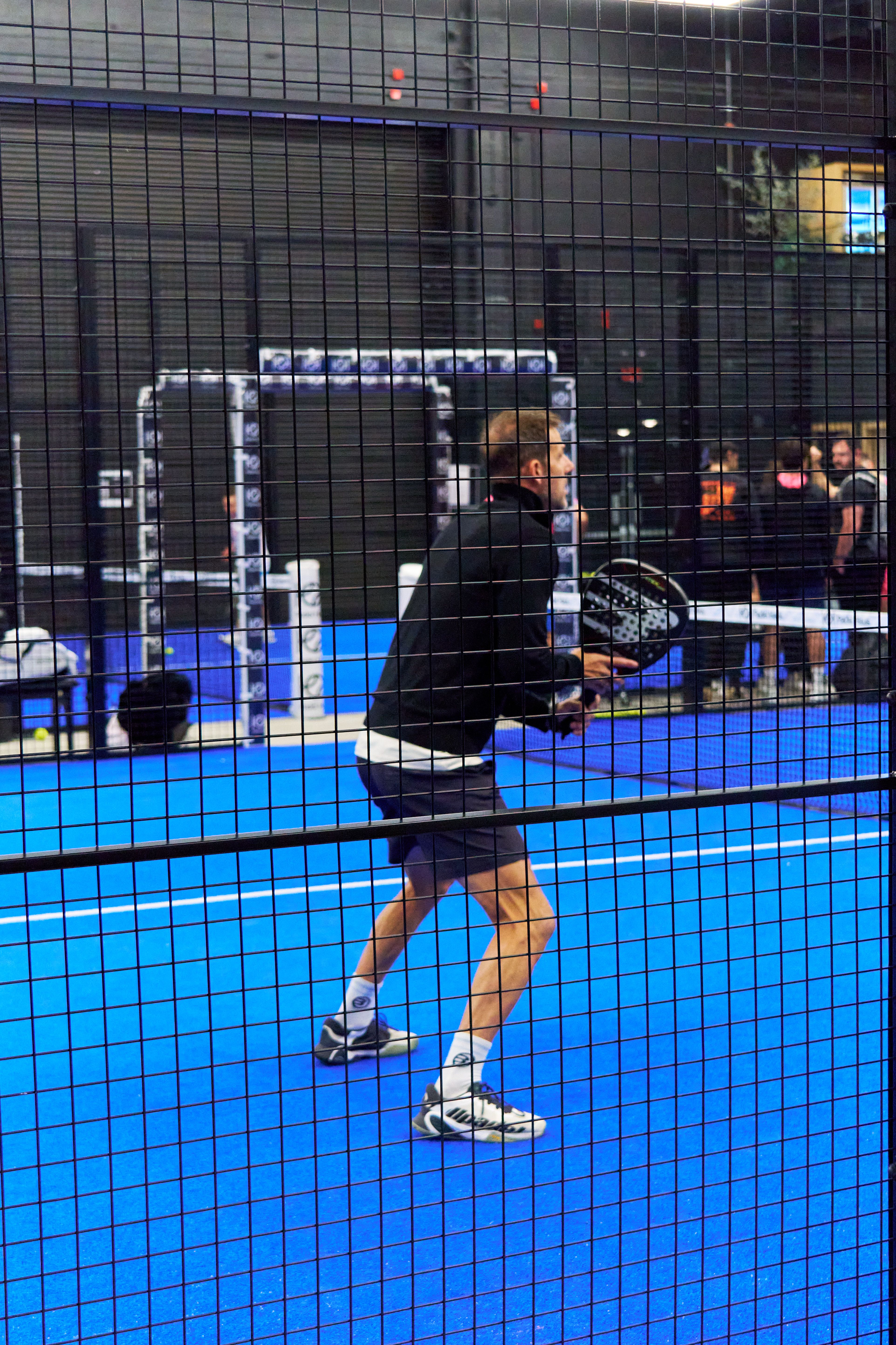 Man playing padel in an indoor sports event with catering.